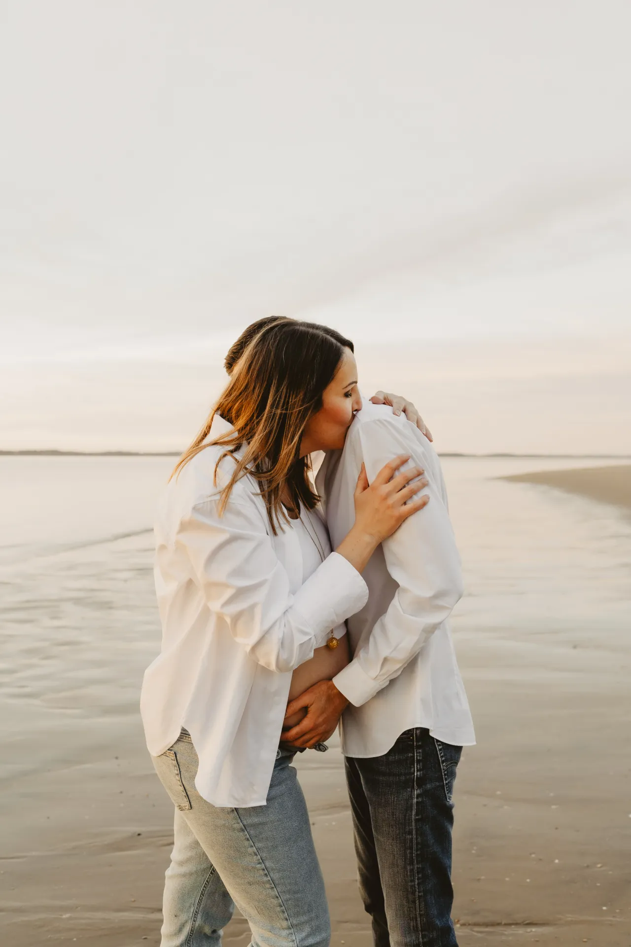 Mains entrelacées du couple sur le ventre arrondi de maman