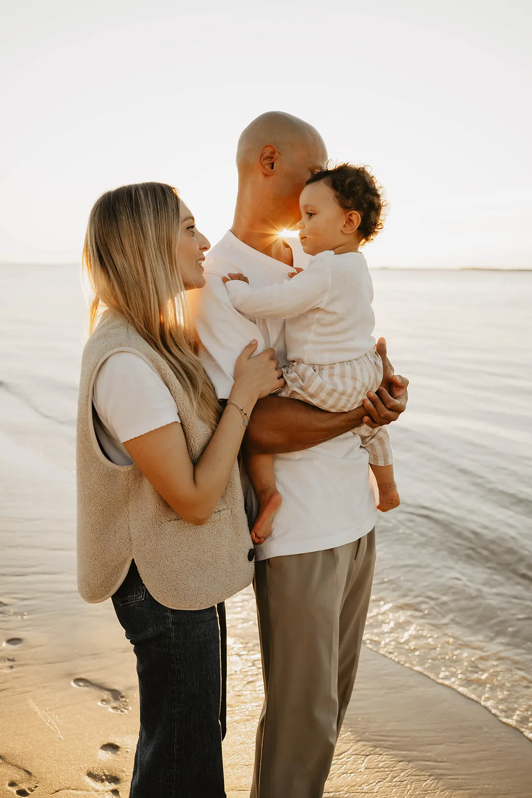 Papa et maman embrassant leur enfant sur les joues