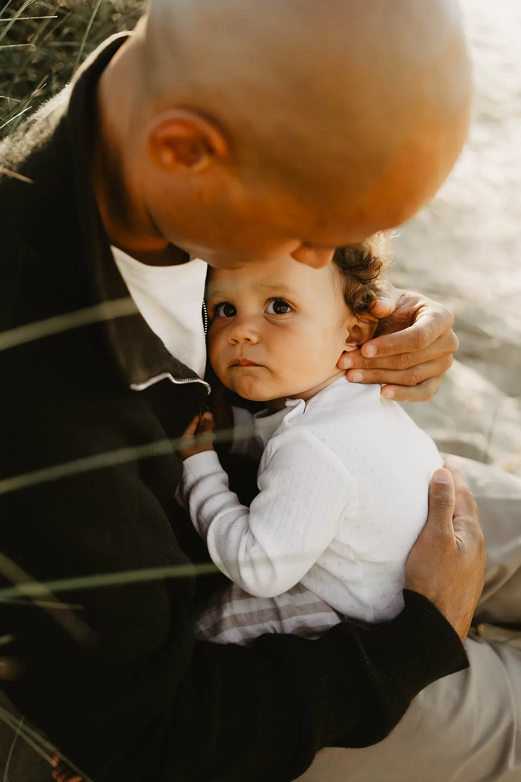 Famille allongée dans le sable se regardant avec tendresse