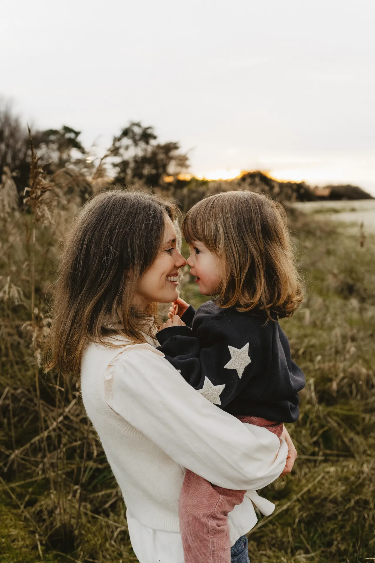 Frères et soeurs enlacés souriant au photographe