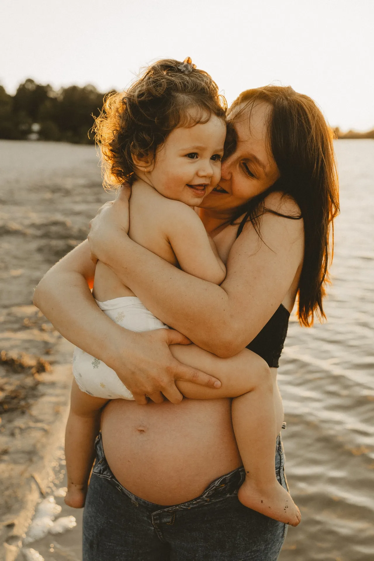 Couple enlacé lors d'une séance photo grossesse en extérieur