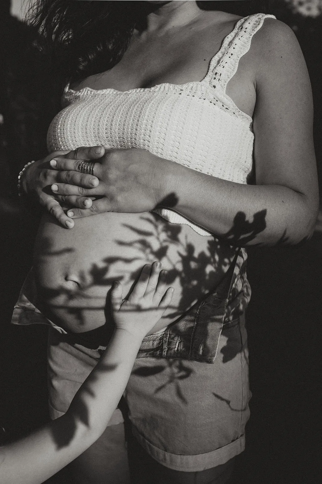 Ventre rond en gros plan, mains délicates posées dessus