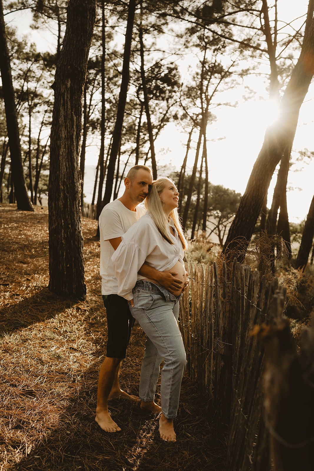 Maman enceinte souriant au photographe en pleine nature