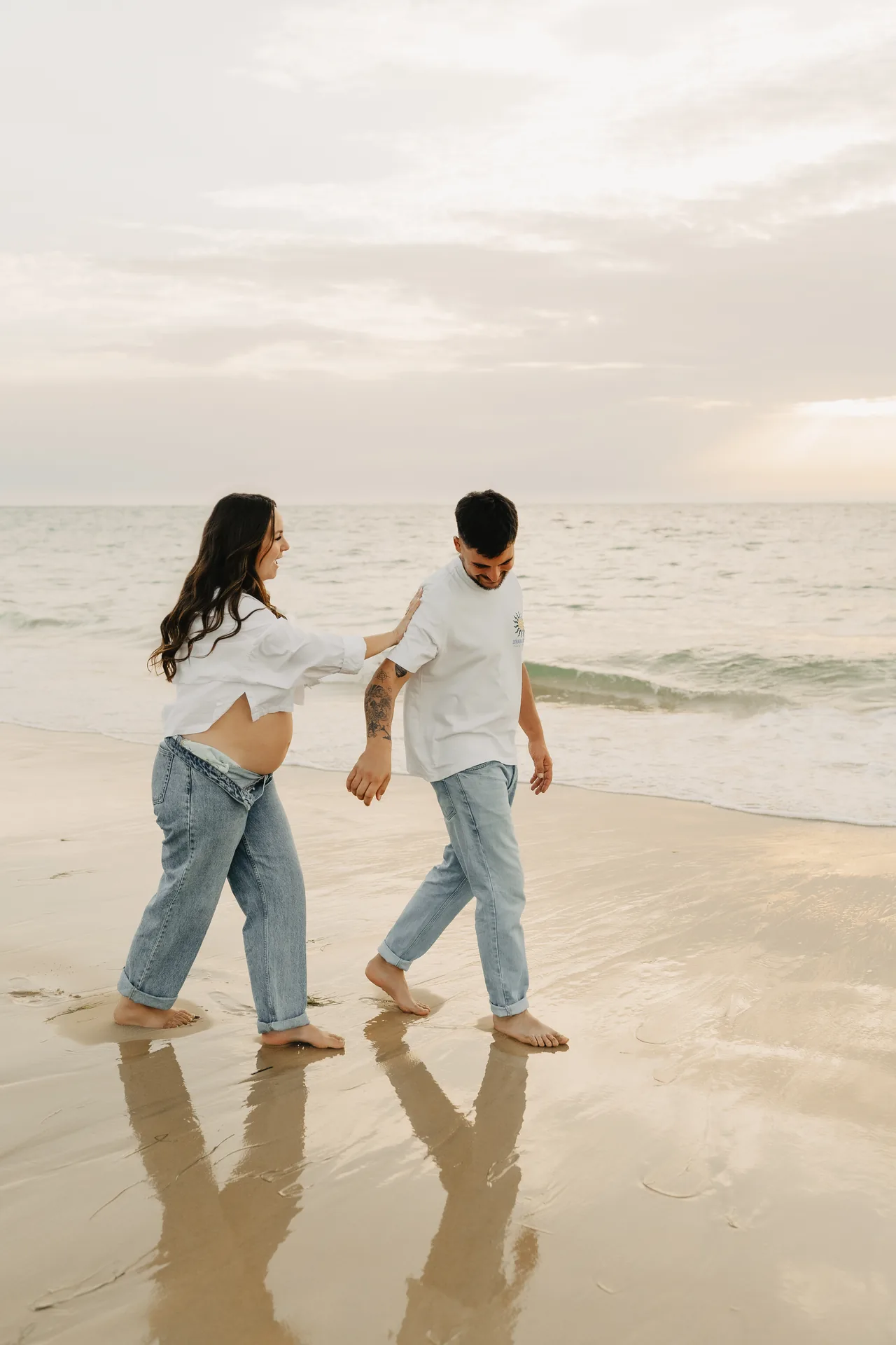 Couple marchant les pieds dans l'eau au coucher du soleil