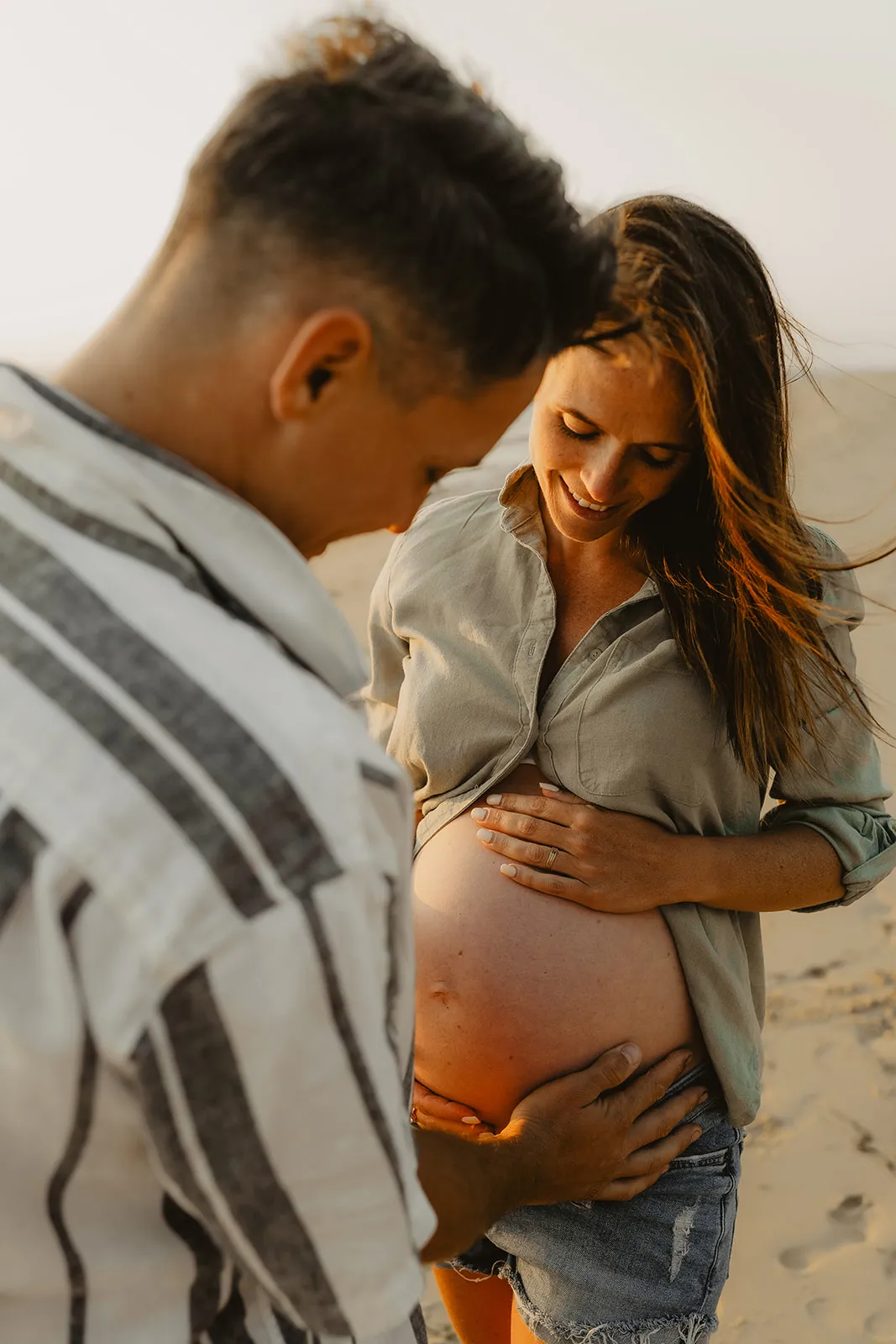 Papa tenant maman par la taille lors de la séance maternité