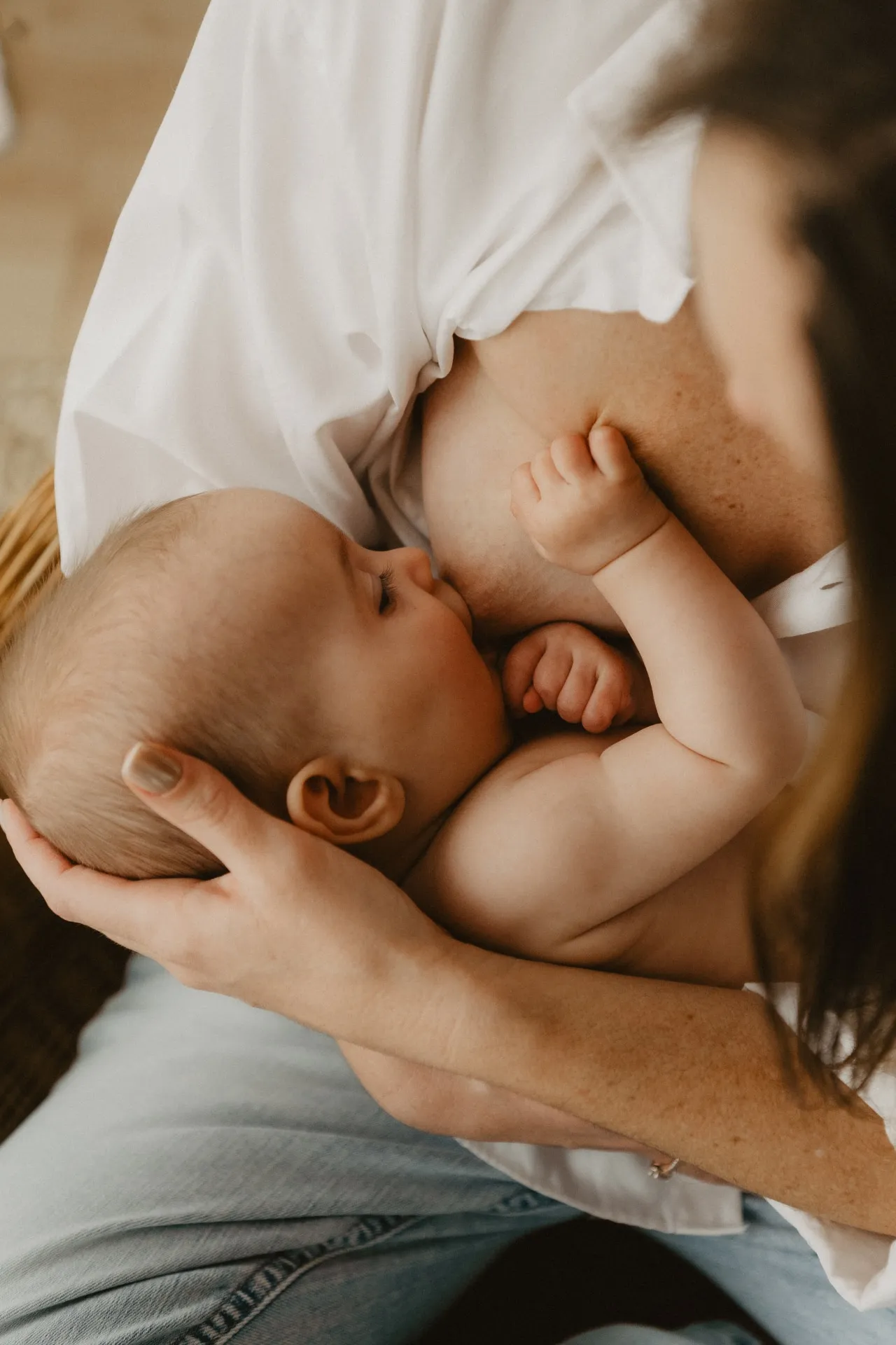 Maman allaitant son bébé en lumière naturelle au studio