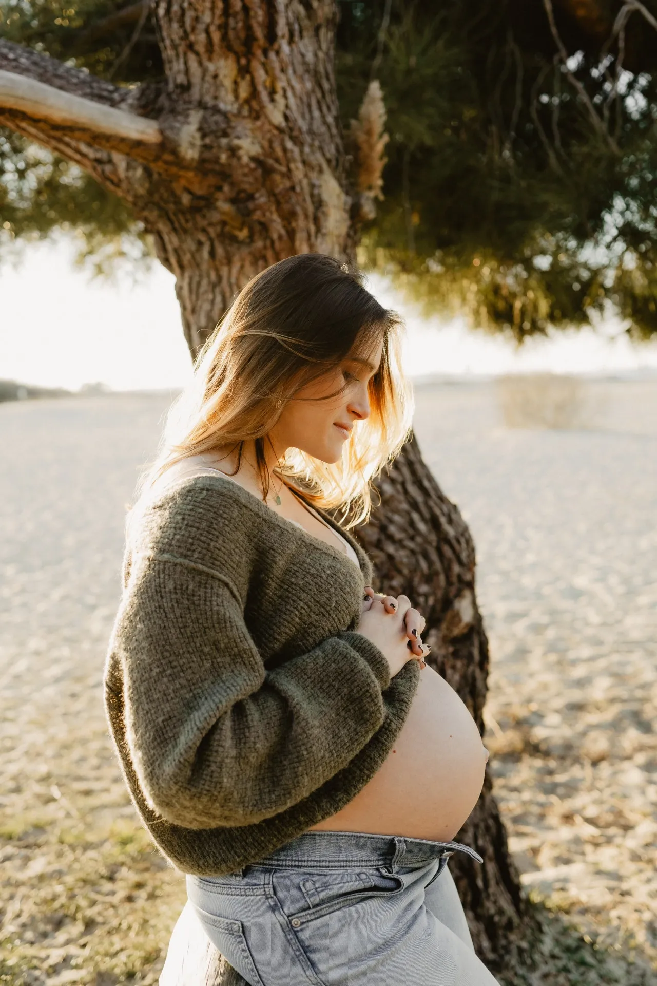 Couple attendant bébé, mains posées sur le ventre rond