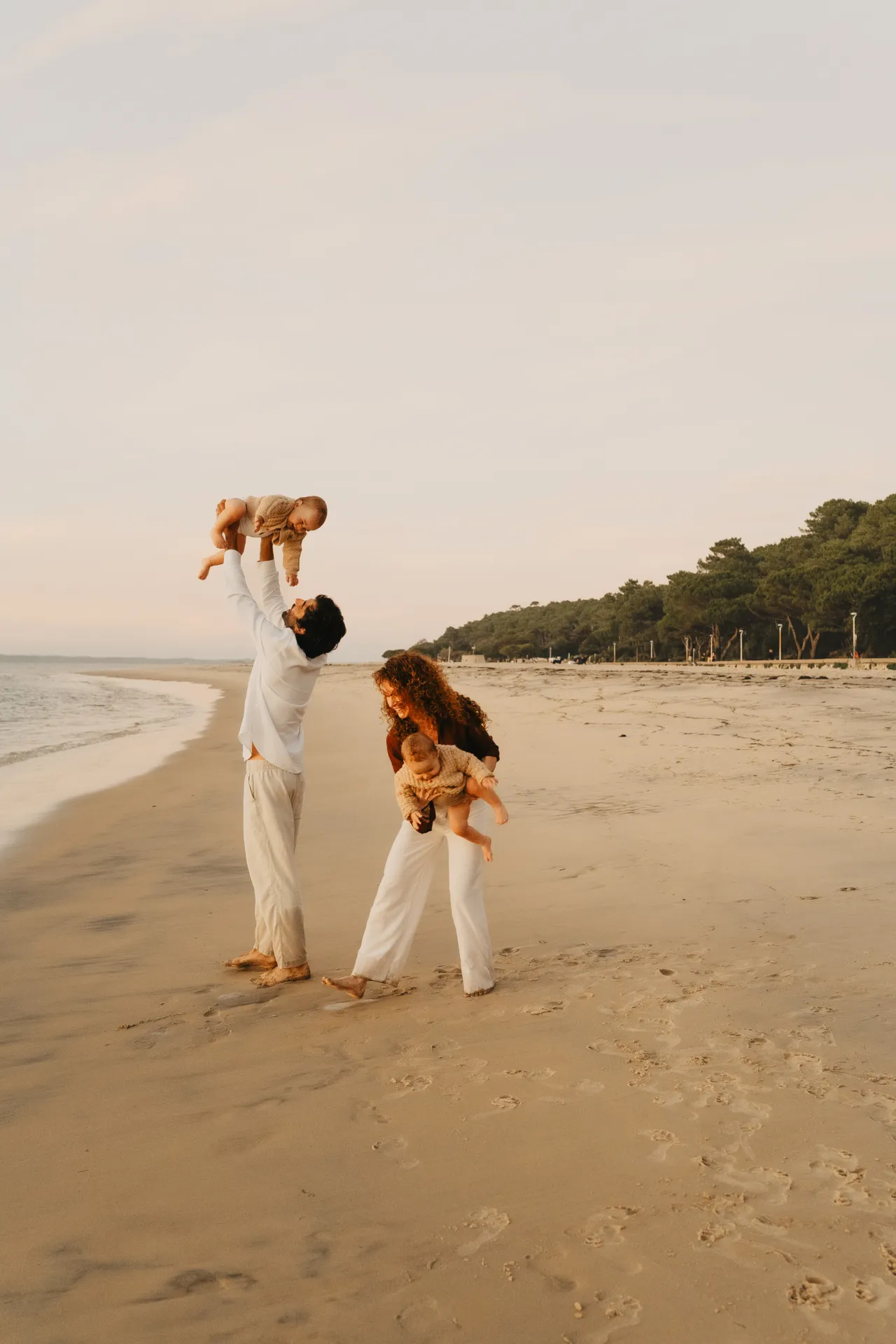 Enfant riant dans les bras de ses parents