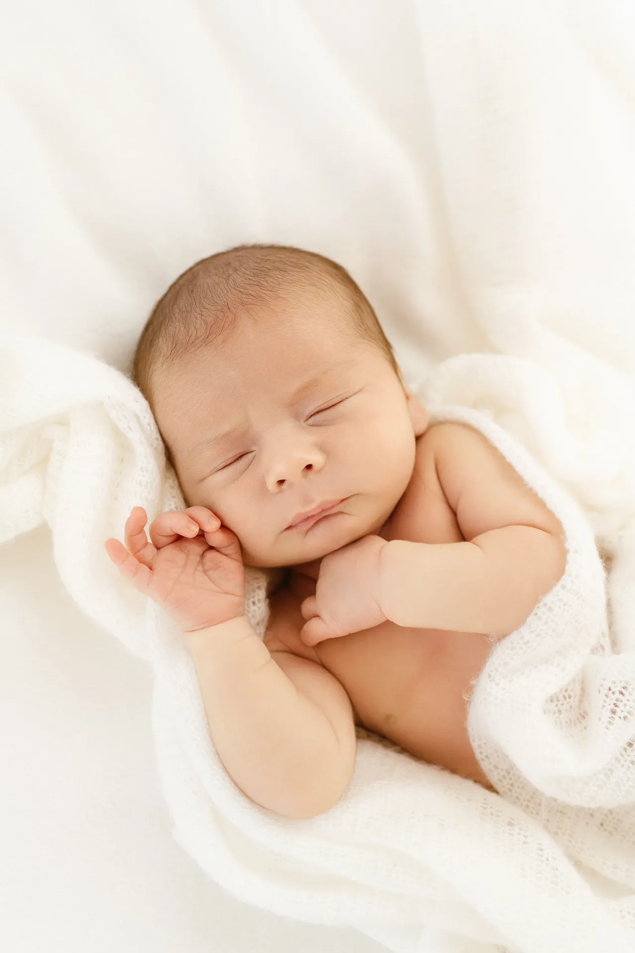 Nouveau-né emmailloté dormant sur un tissu en coton