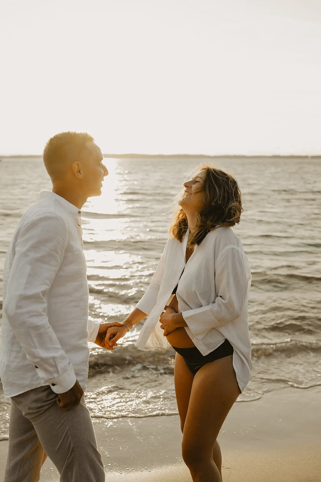 Maman caressant son ventre arrondi en bord de mer