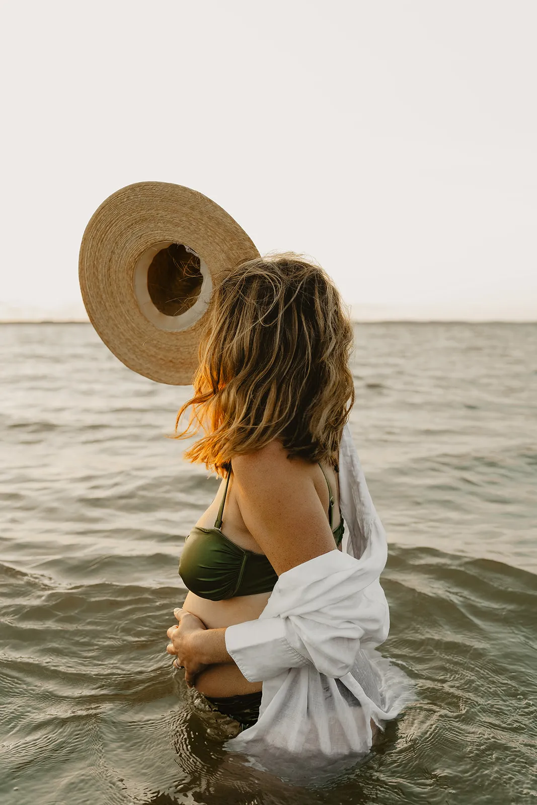 Femme enceinte contemplant l'horizon sur la plage