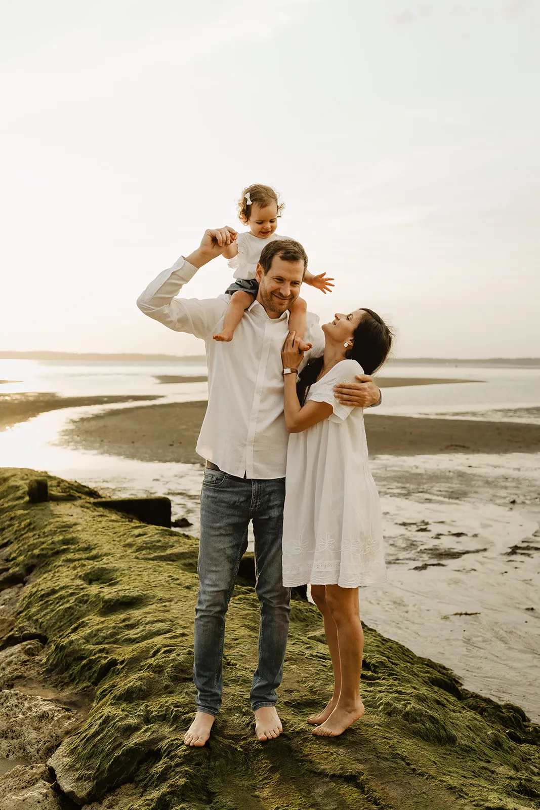 Famille assise sur le sable regardant la mer