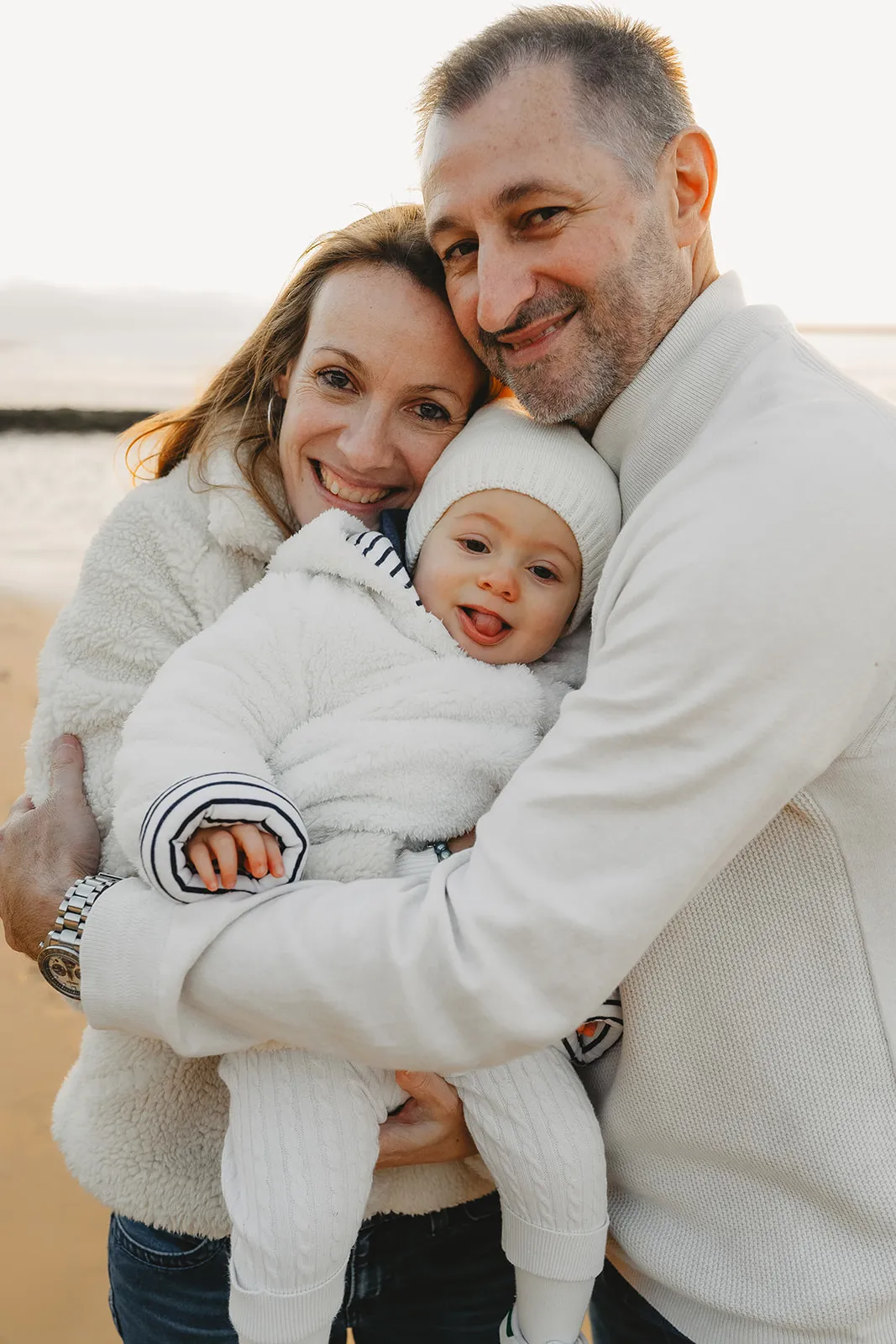 Parents et enfant en silhouette devant le ciel doré